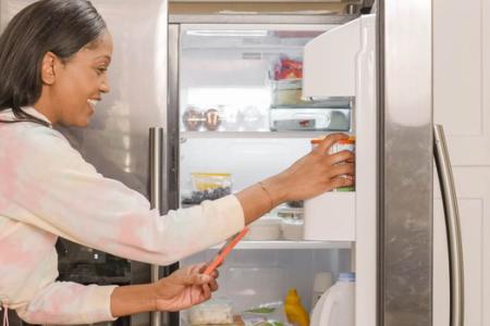 frau am kuehlschrank
